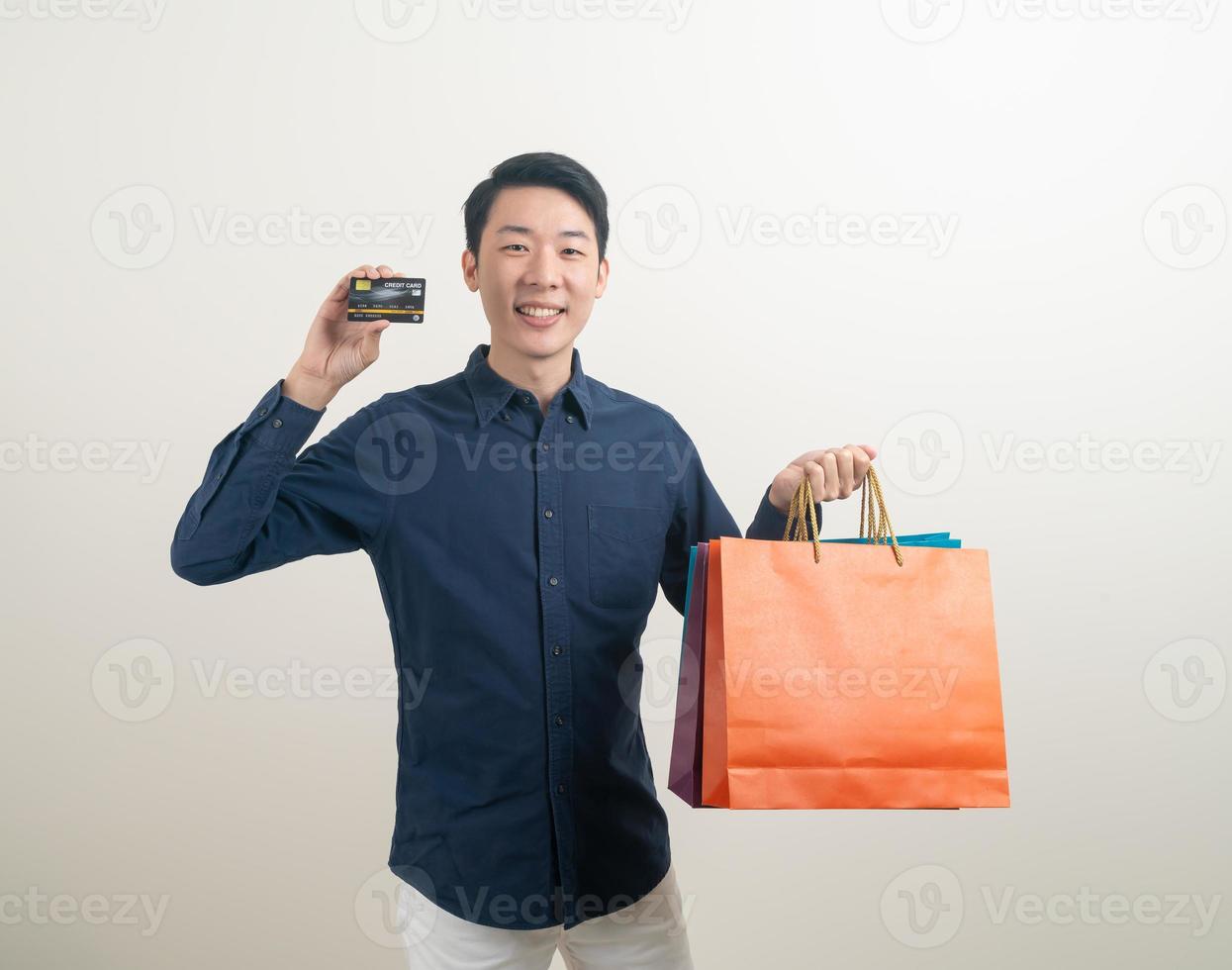 retrato, joven, asiático, hombre, tenencia, tarjeta de crédito, y, bolsa de compras foto
