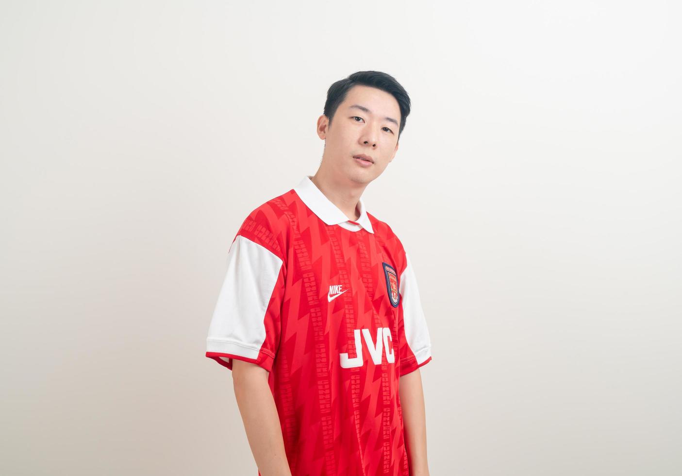 Bangkok, Tailandia - 27 de noviembre de 2021 - joven asiático vistiendo la camiseta del arsenal con fondo blanco. foto