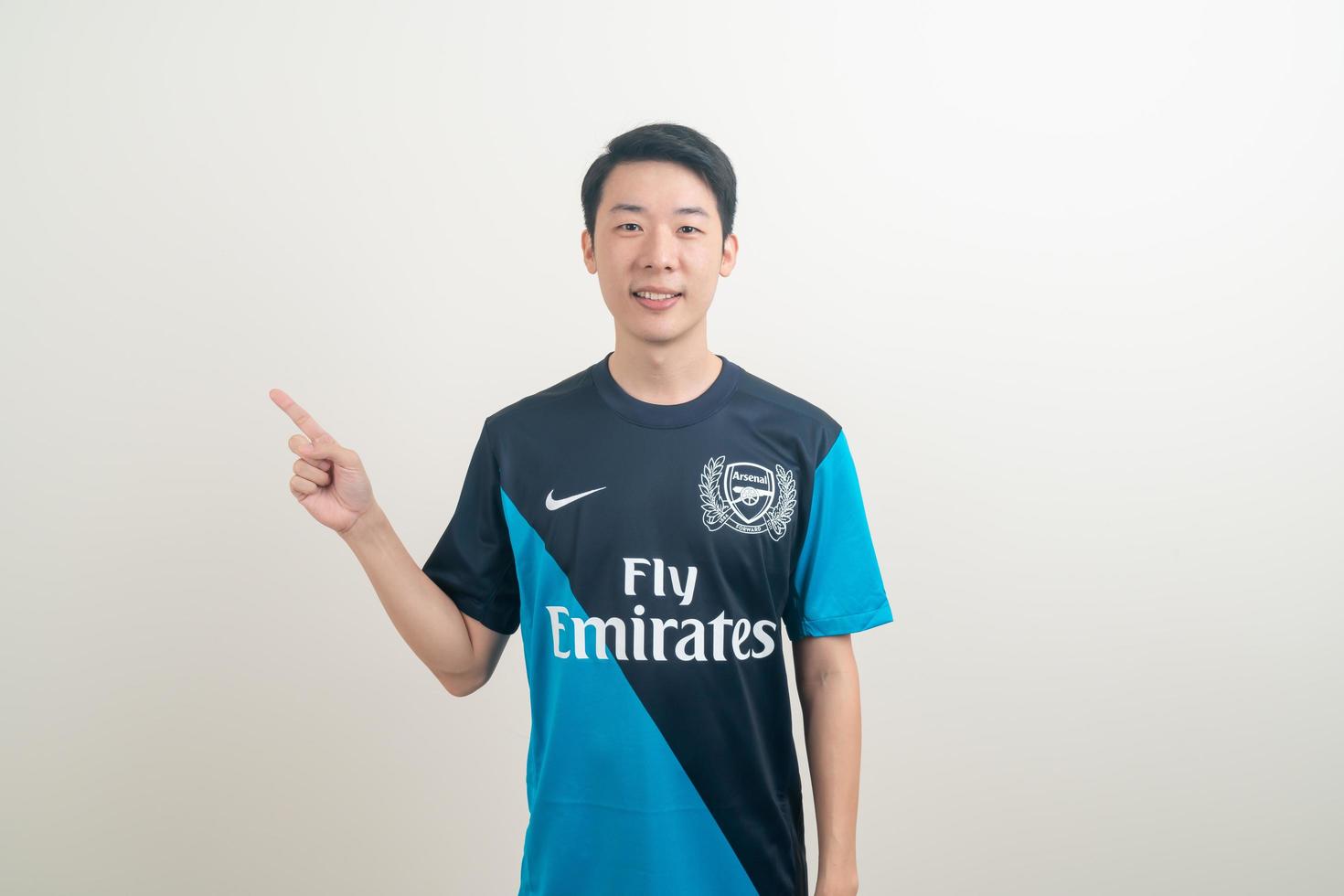 Bangkok, Tailandia - 27 de noviembre de 2021 - joven asiático vistiendo la camiseta del arsenal con fondo blanco. foto