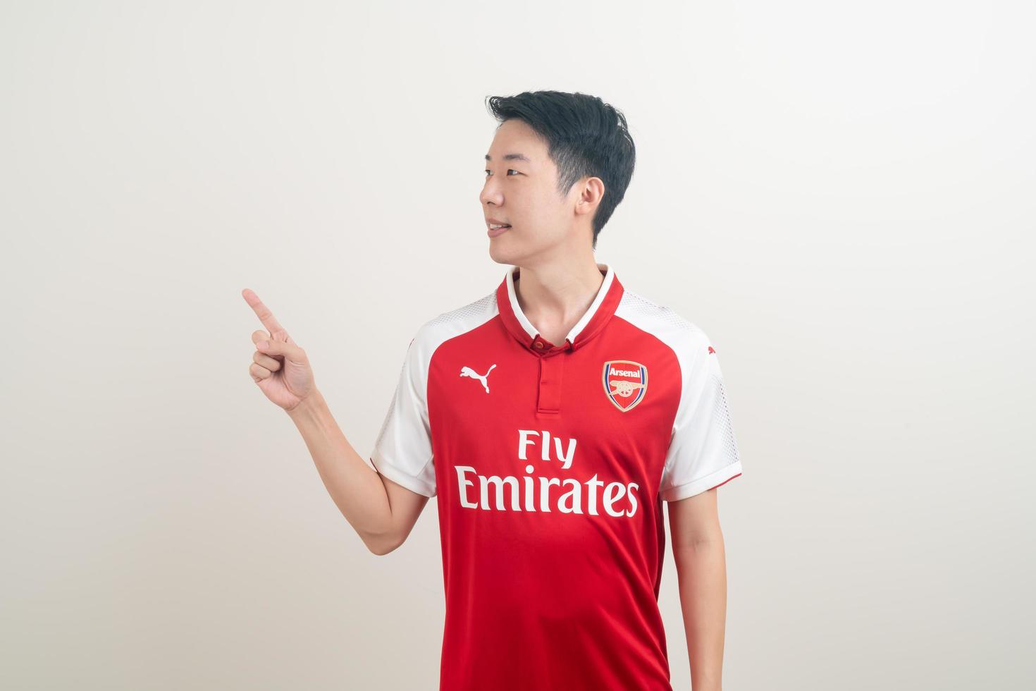 Bangkok, THAILAND - Nov 27, 2021 - Young Asian man wearing Arsenal shirt with white background. photo