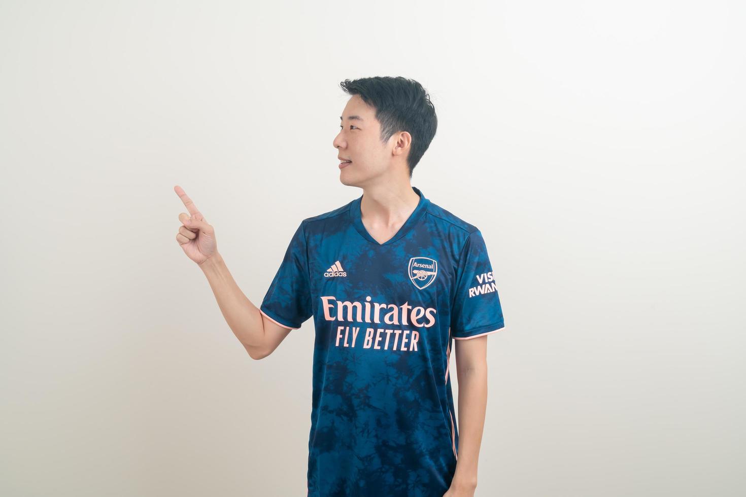 Bangkok, Tailandia - 27 de noviembre de 2021 - joven asiático vistiendo la camiseta del arsenal con fondo blanco. foto