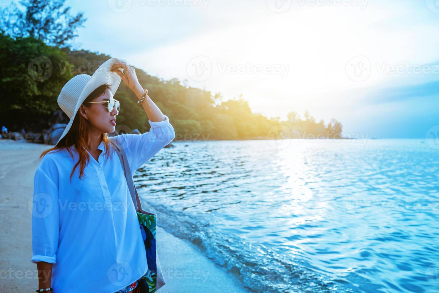 naturaleza de viaje de mujer asiática. viajar relajarse. caminando en la playa. en el verano foto