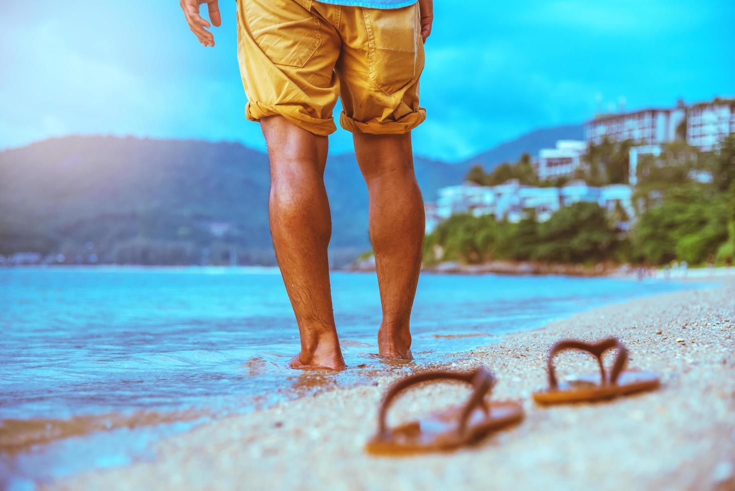 naturaleza de viaje de hombre asiático. viajar relajarse. caminando en la playa. en el verano foto