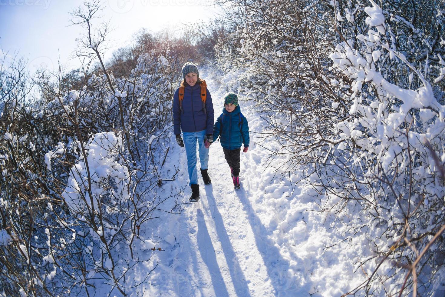 mujer con un niño en una caminata de invierno en las montañas. foto