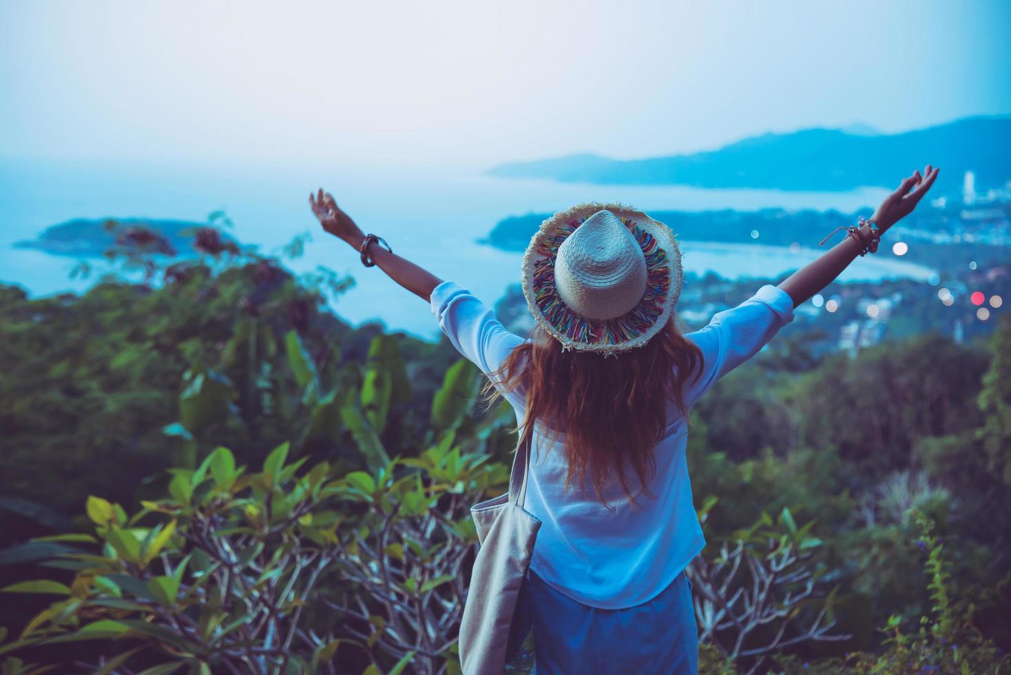 Woman travel relax the beach raised arms happy against sunset. in summer photo