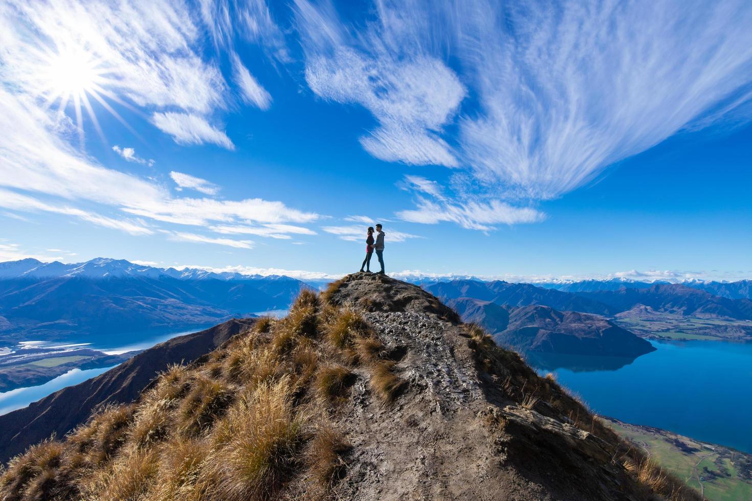 Joven pareja asiática tomados de la mano besándose en el pico de Roy, el lago Wanaka, Nueva Zelanda foto