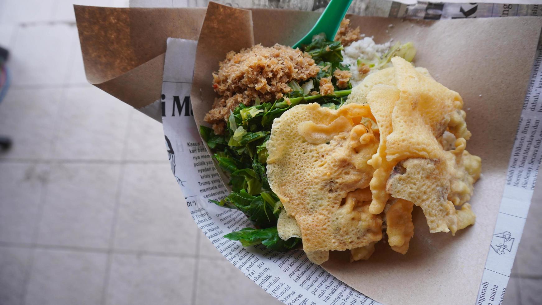 comida indonesia, arroz de maíz con una mezcla de salsa de coco, verduras y patatas fritas foto