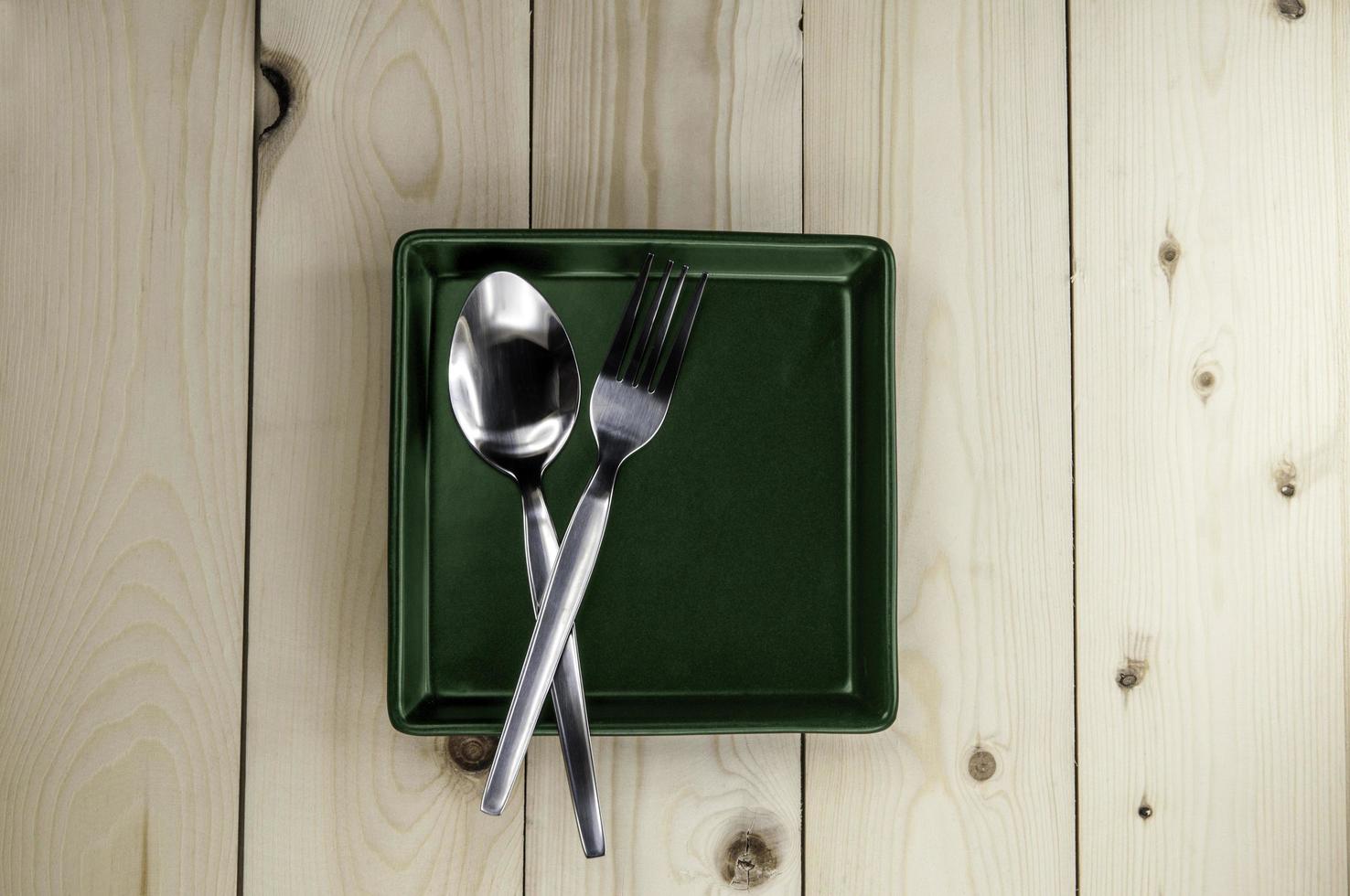 plato y cubiertos en la mesa de madera foto