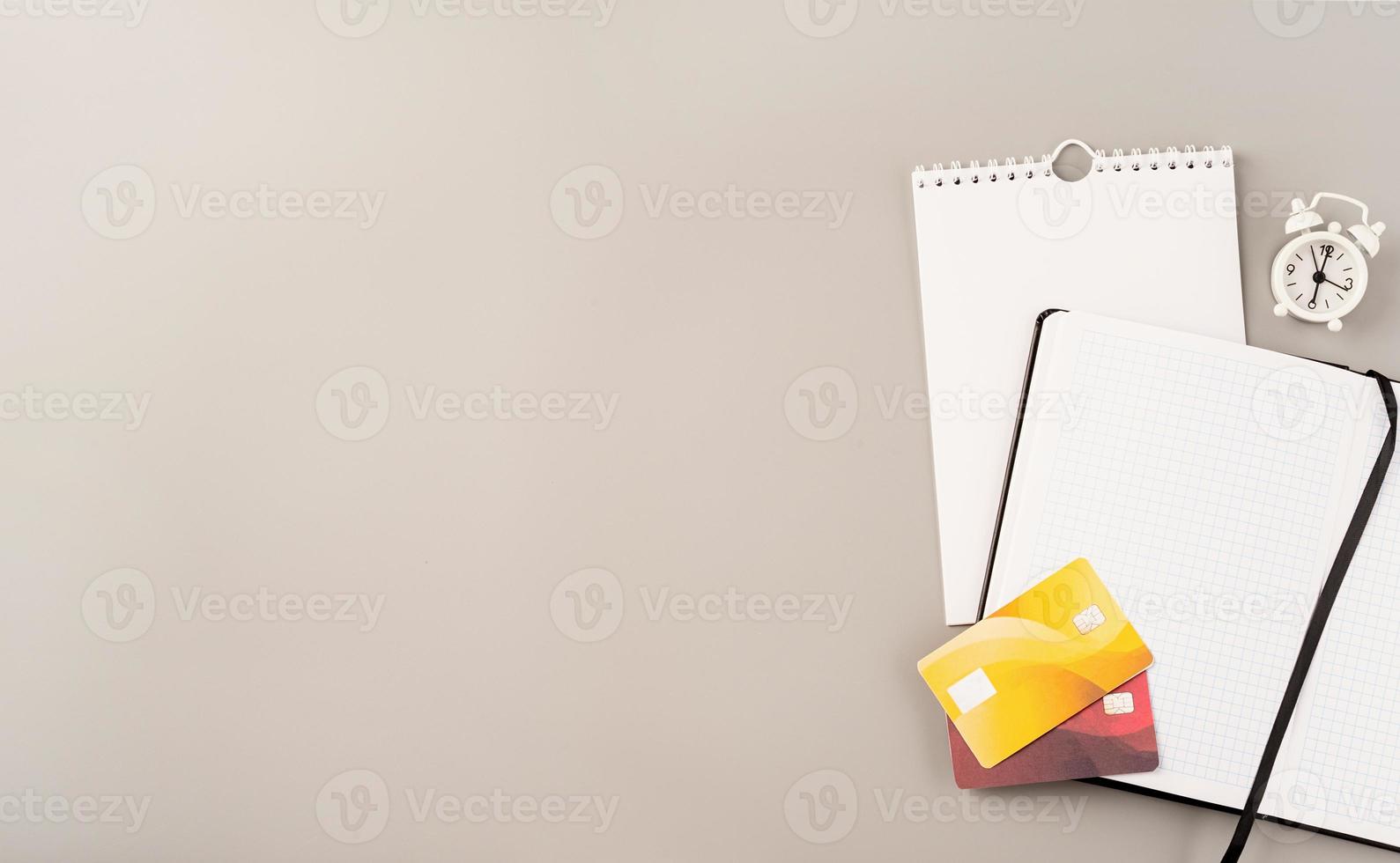 Vista superior calendario en blanco, cuaderno y tarjetas de crédito sobre fondo gris claro foto