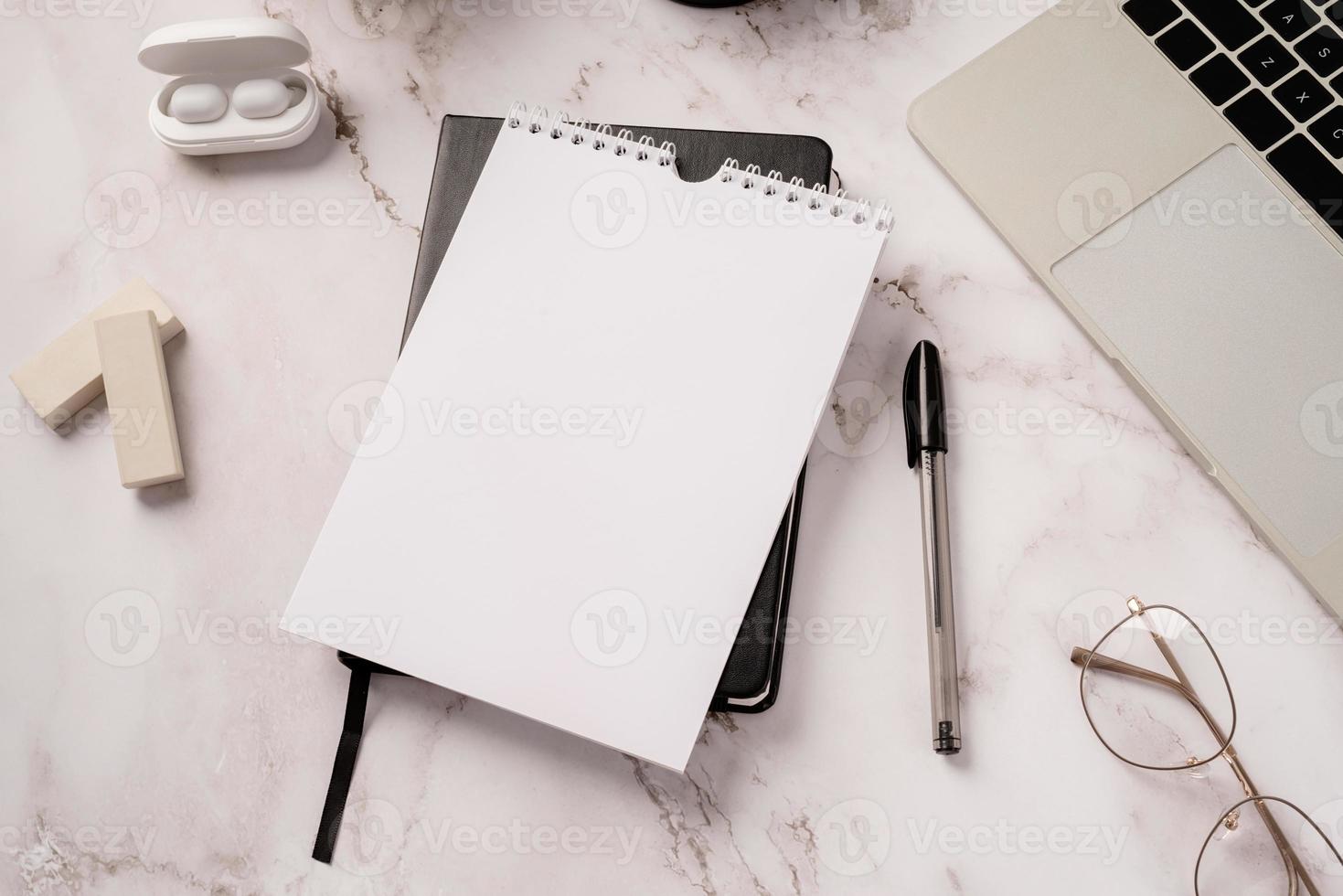 Top view desktop blank calendar, notebook and laptop on light gray marble background photo