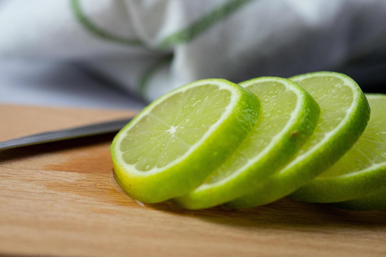 Thinly sliced lime. Preparation of citrus for drinks. photo
