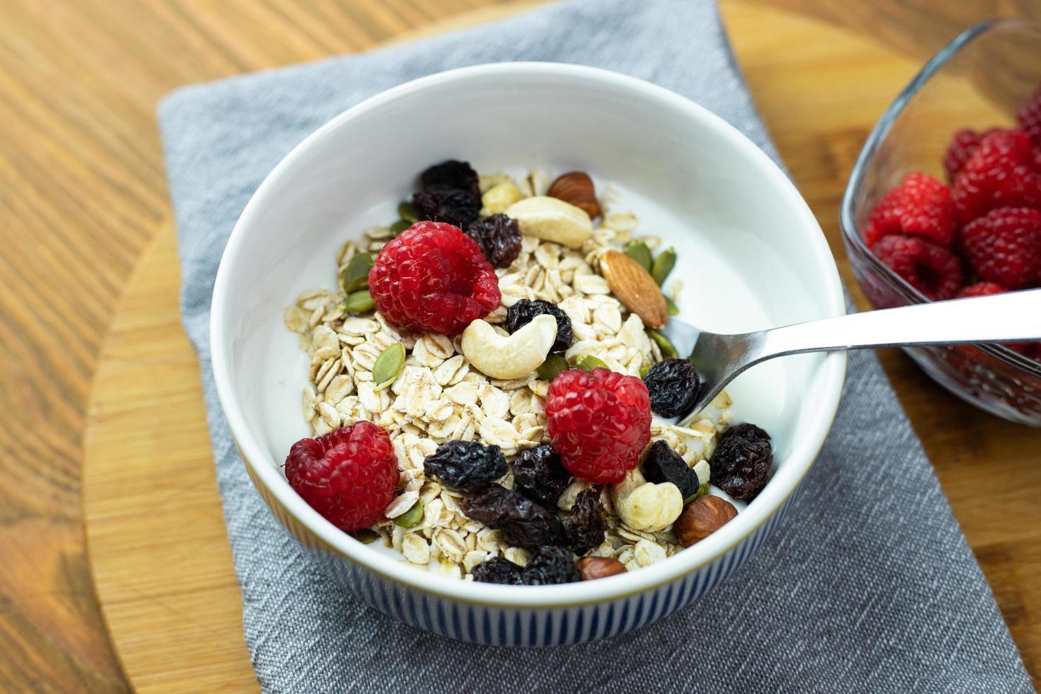 Oatmeal with raspberries, nuts and natural yoghurt. Healthy breakfast. photo