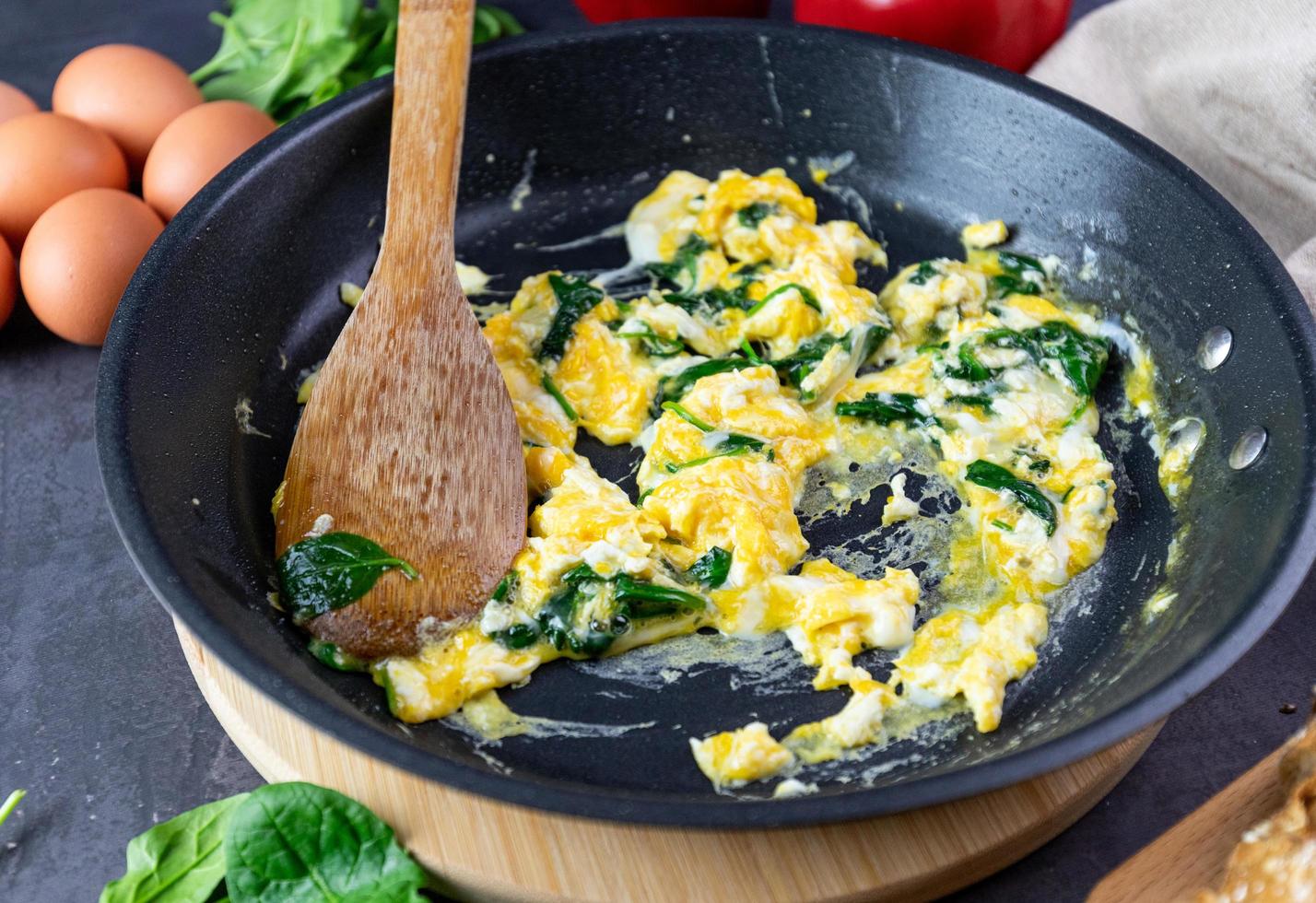 Scrambled eggs with spinach in a pan photo