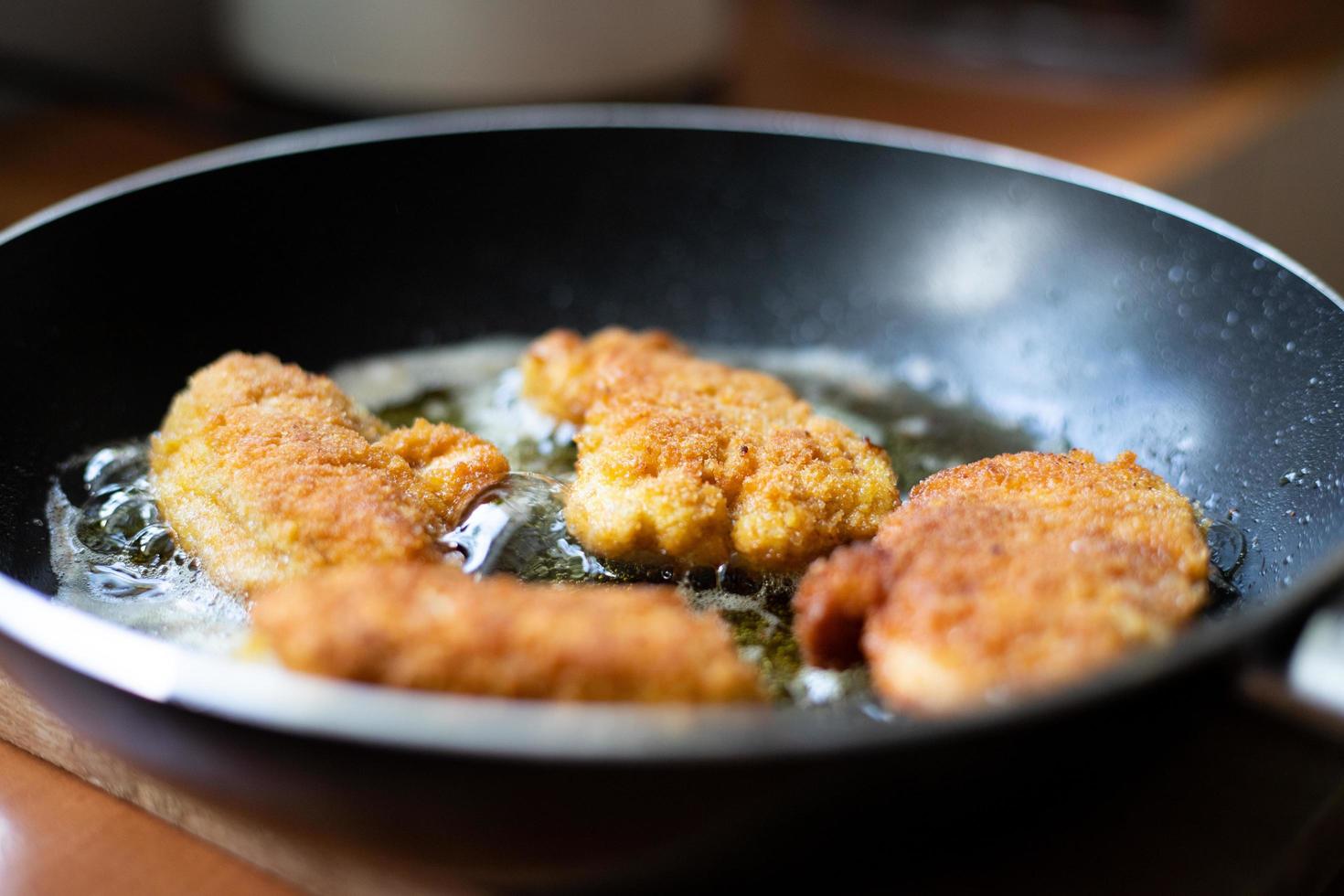 Fried pieces of breaded chicken. Preparation of a traditional dinner. photo