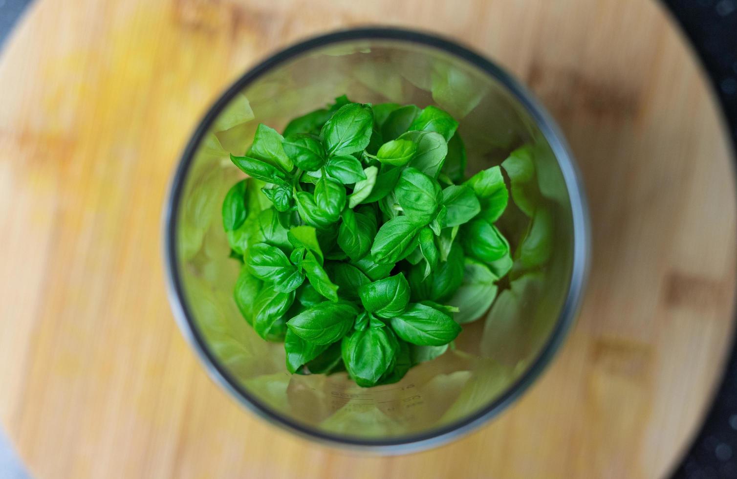 Basil leaves thrown into a blender. Prepare basil pesto. photo