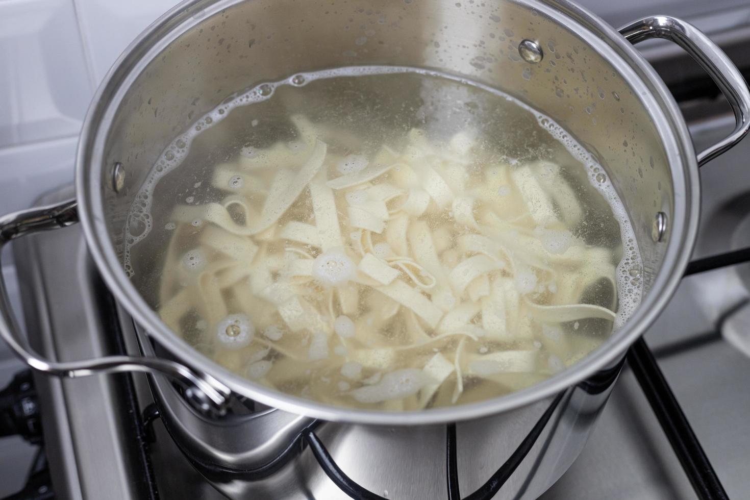 Pasta strips cooked in a kitchen pot. Close-up view. photo