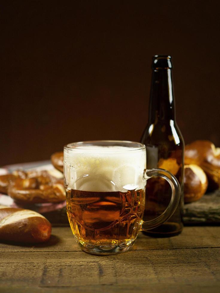 cerveza en una taza rodeada de pretzels foto