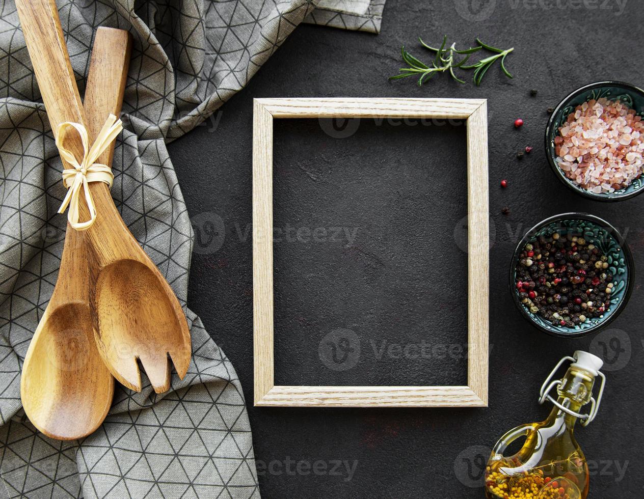 Old wooden kitchen utensils and spices with frame as a border photo