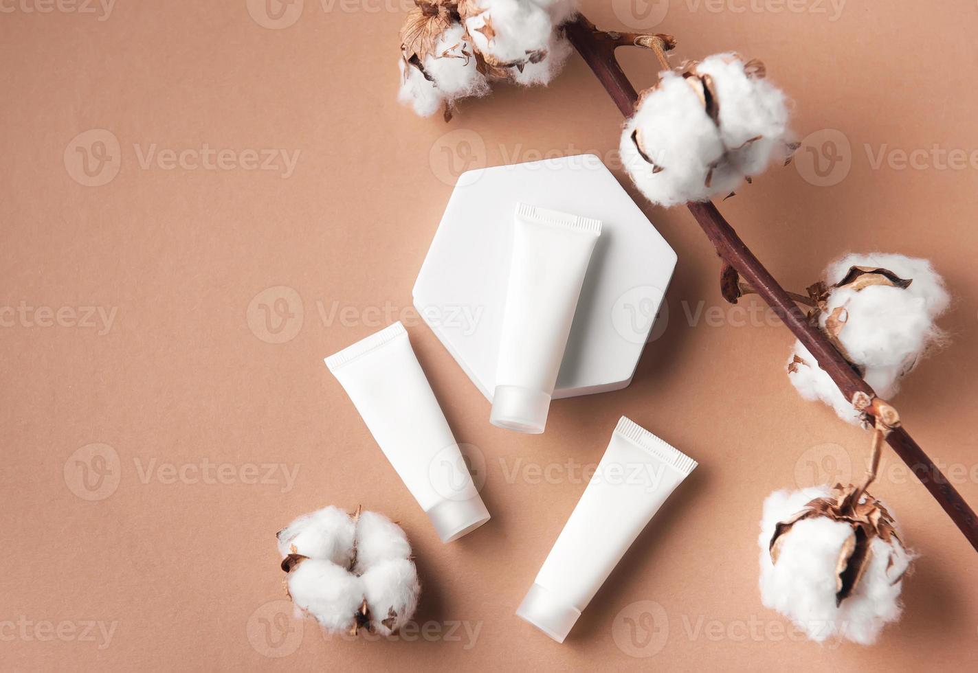 White tubes of cream on a brown background photo