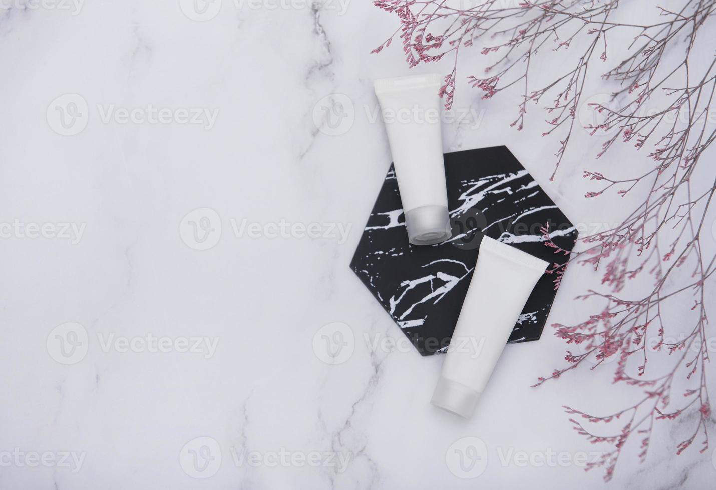 White tubes of cream on a marble background photo