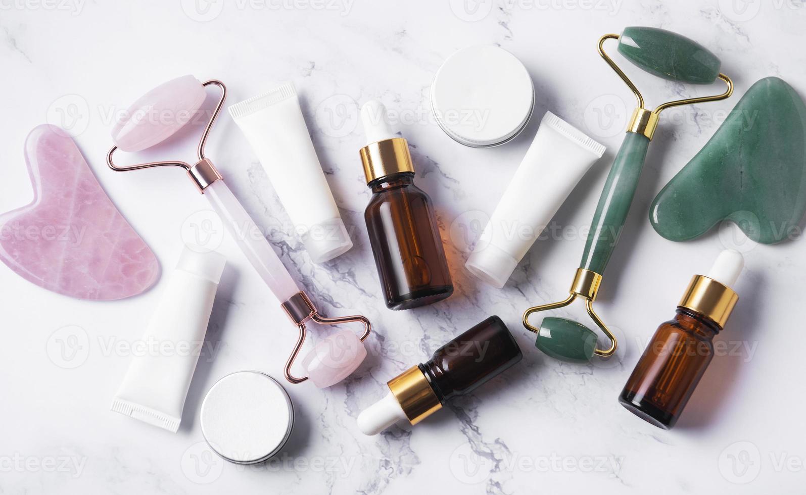 productos cosméticos, tubos de crema, aceites esenciales y rodillo facial foto