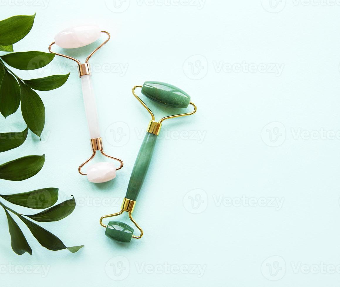 Face massage jade roller  on pastel green background photo
