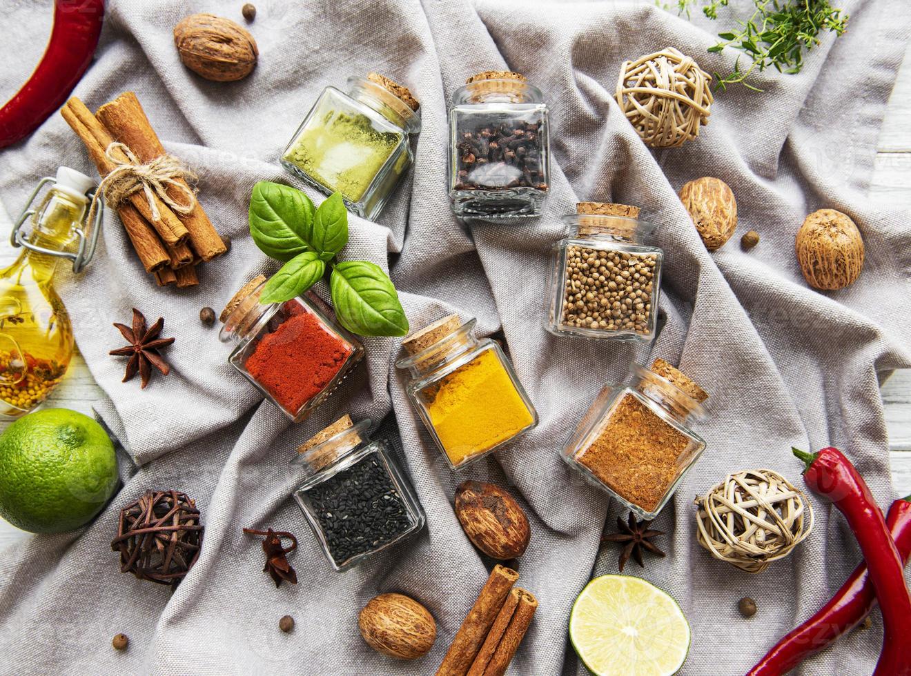 Jars with dried herbs, spices on the table photo