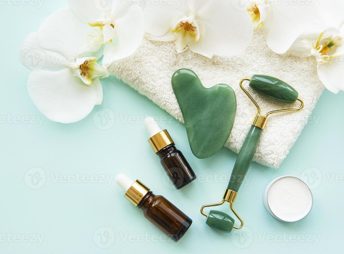 Face massage jade roller  on pastel green background photo