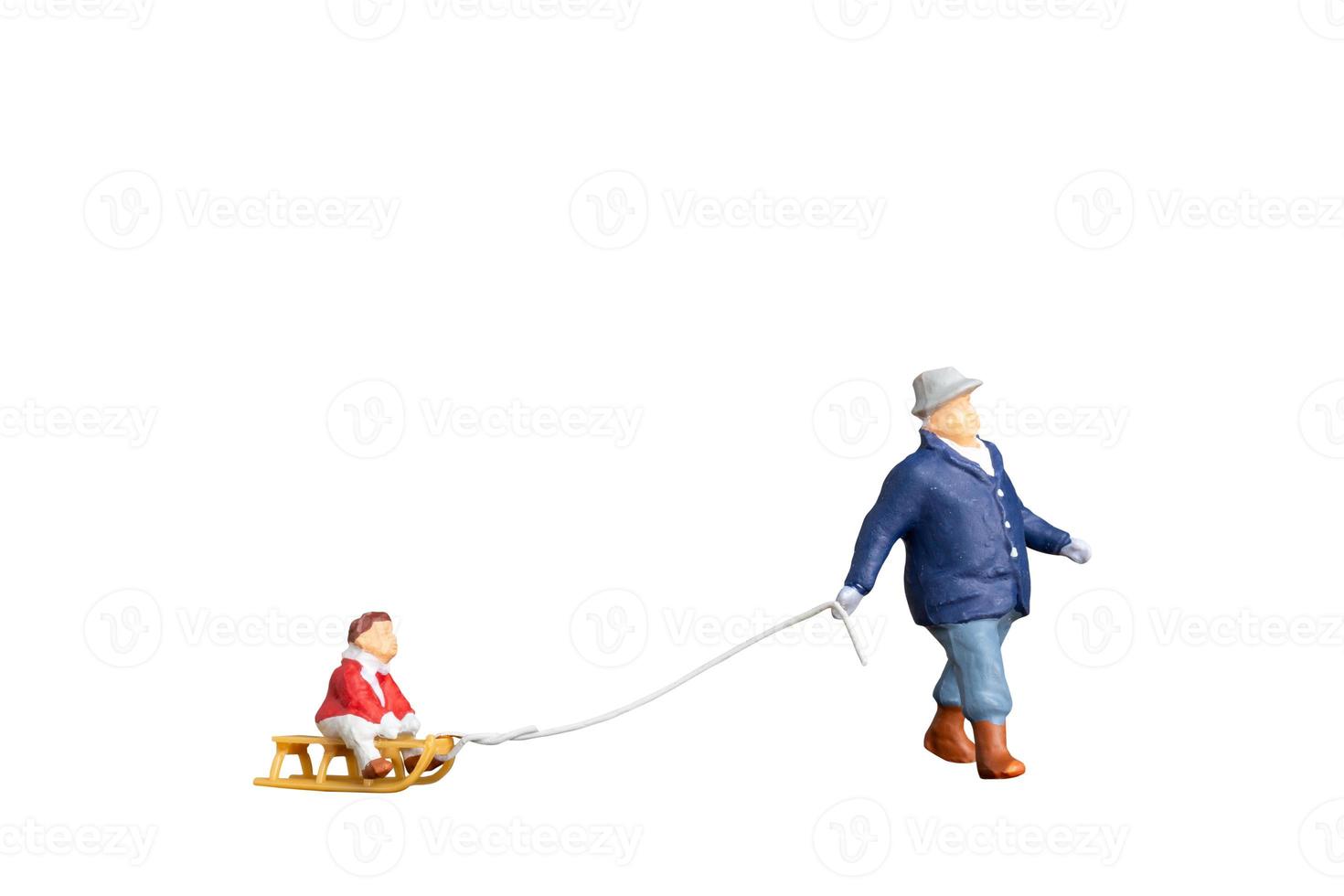 Father towing sledge with child isolated on white background with clipping path photo