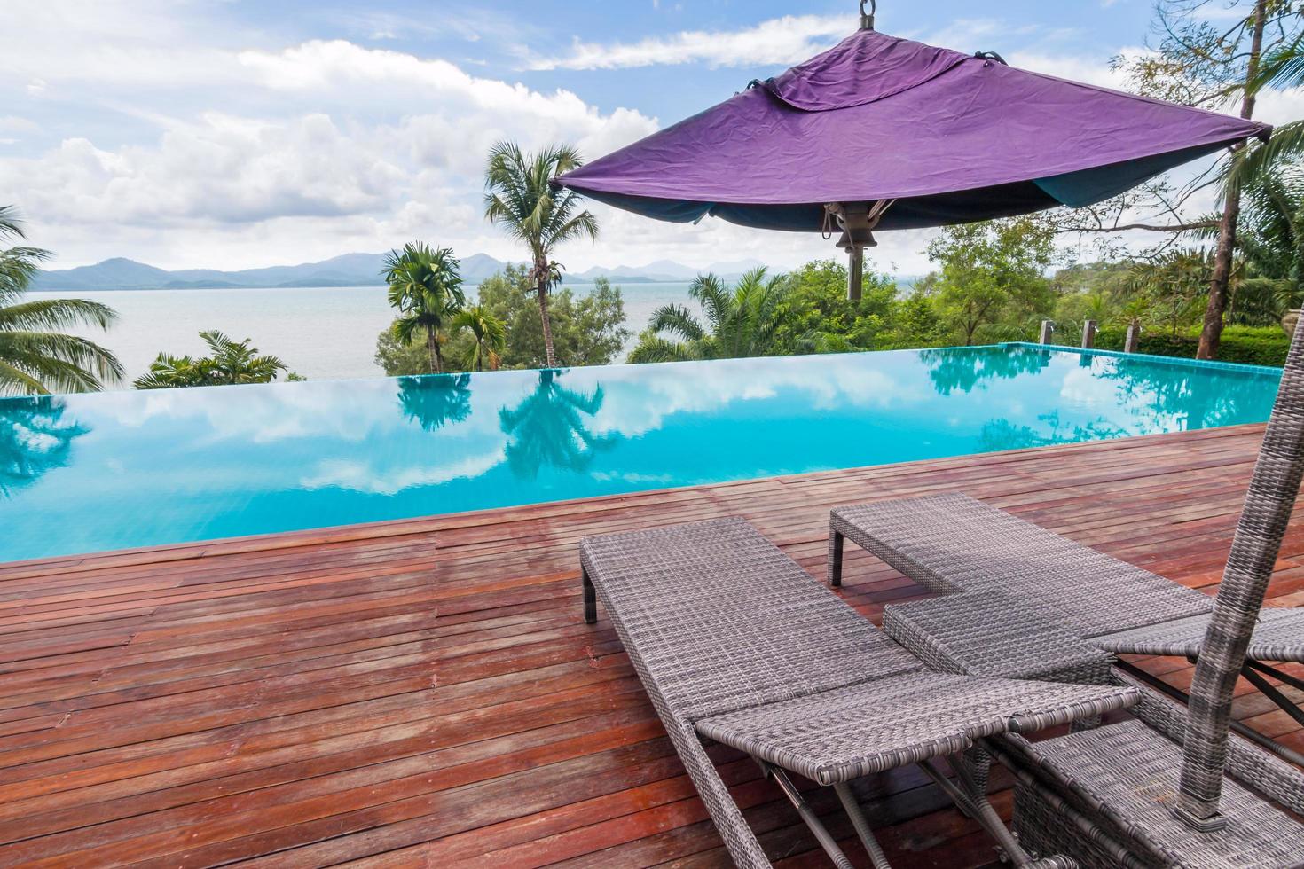 Beach chairs by the swimming pool with beautiful sea view photo