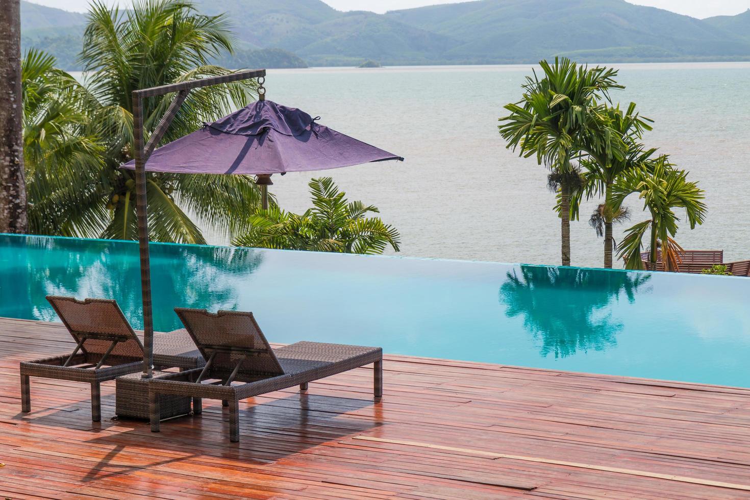 Beach chairs by the swimming pool with beautiful sea view photo