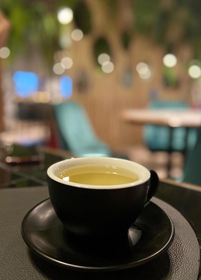 Black mug of freshly brewed green tea photo