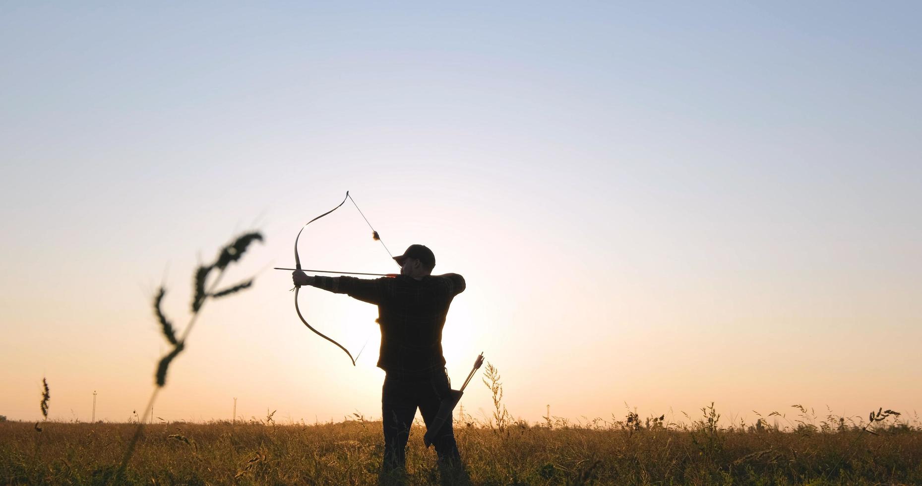 hombre con arco al aire libre en el campo foto