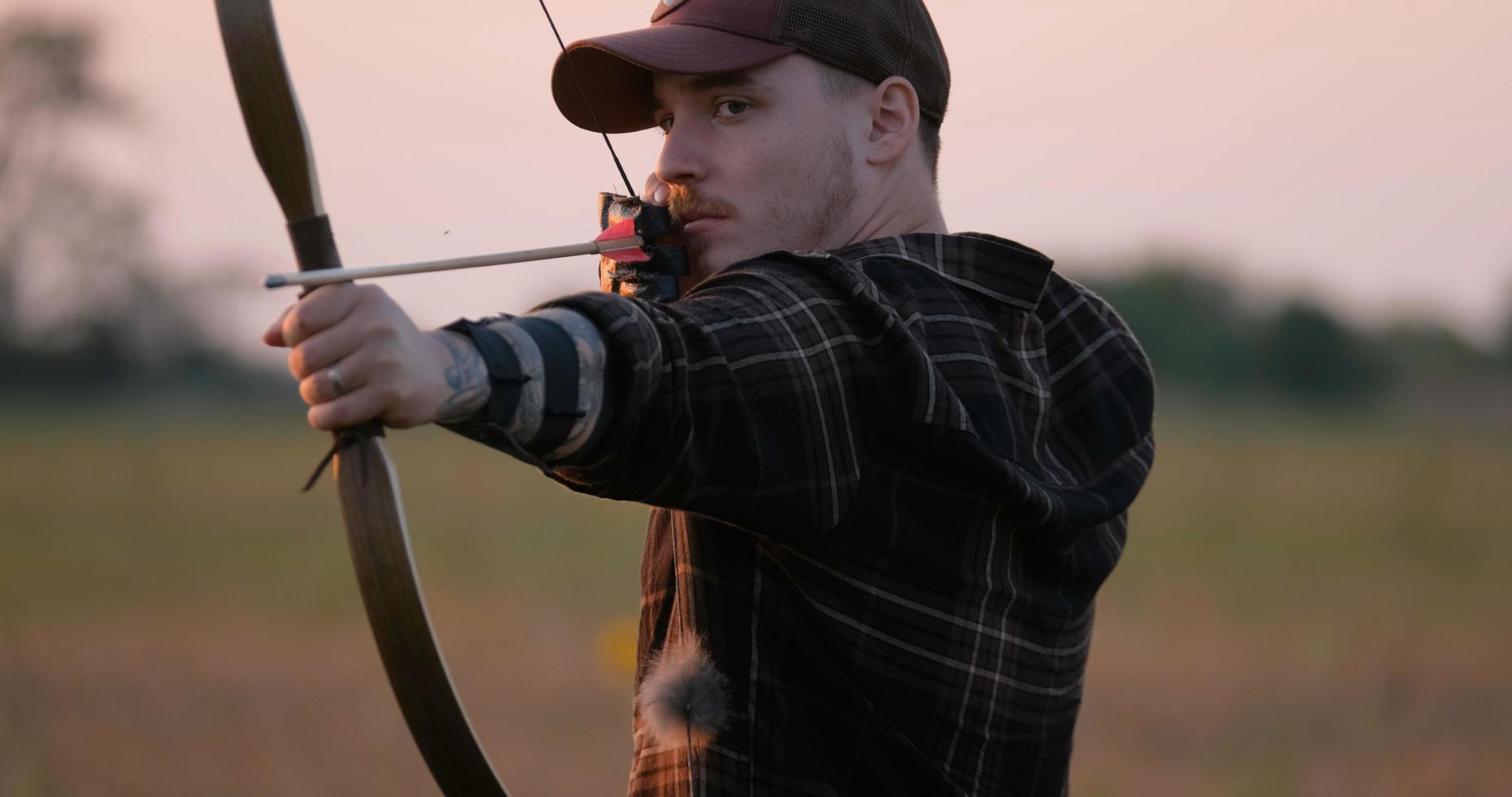 Man with bow outdoors in the field photo