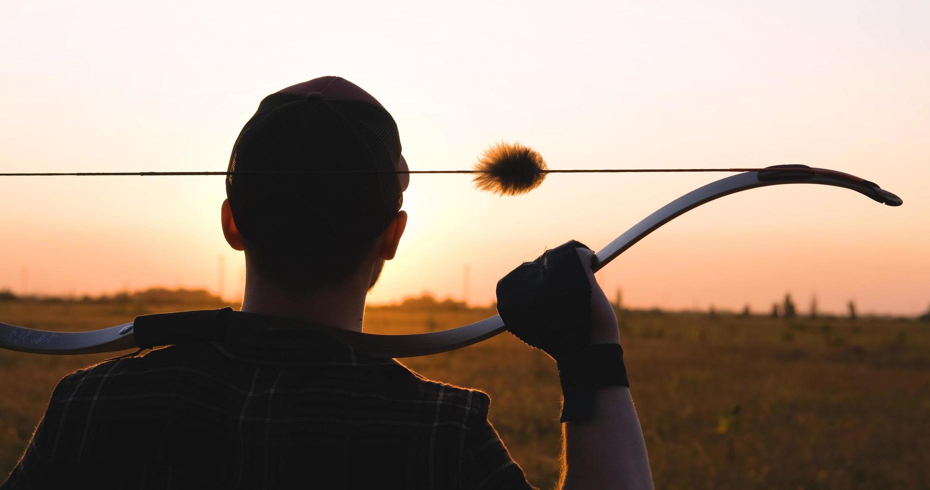Man with bow outdoors in the field photo