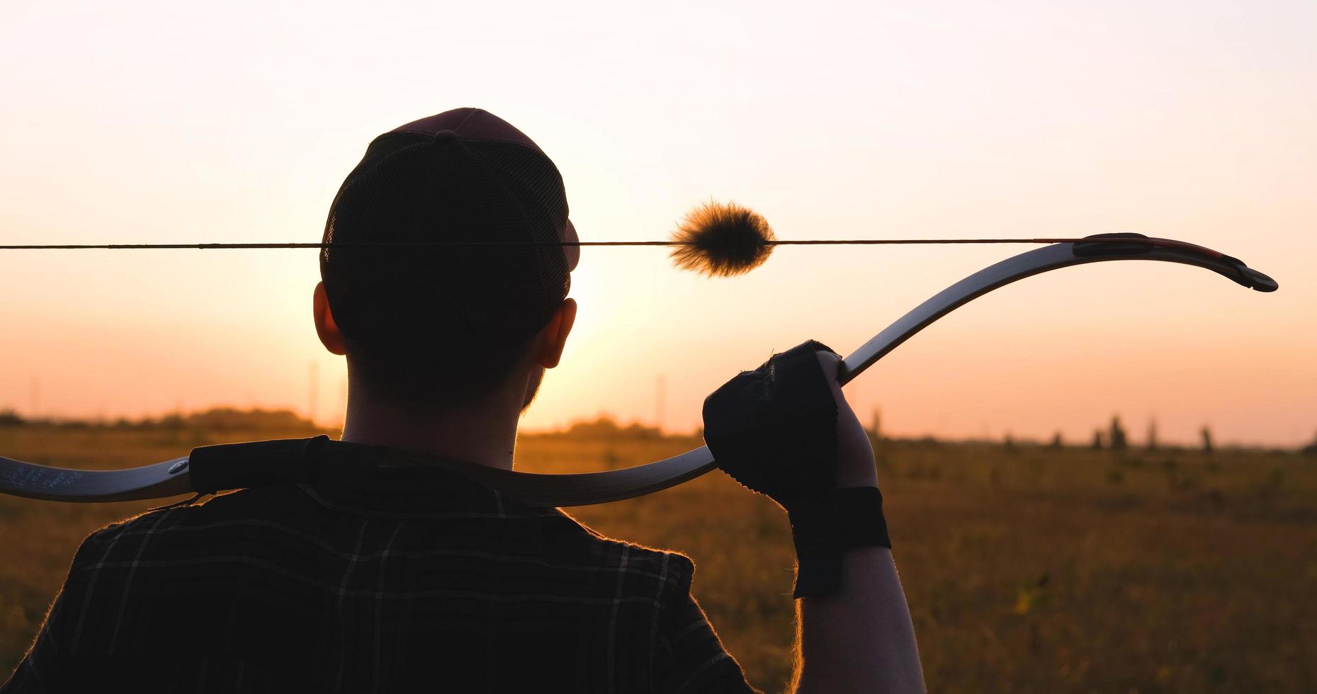 hombre con arco al aire libre en el campo foto