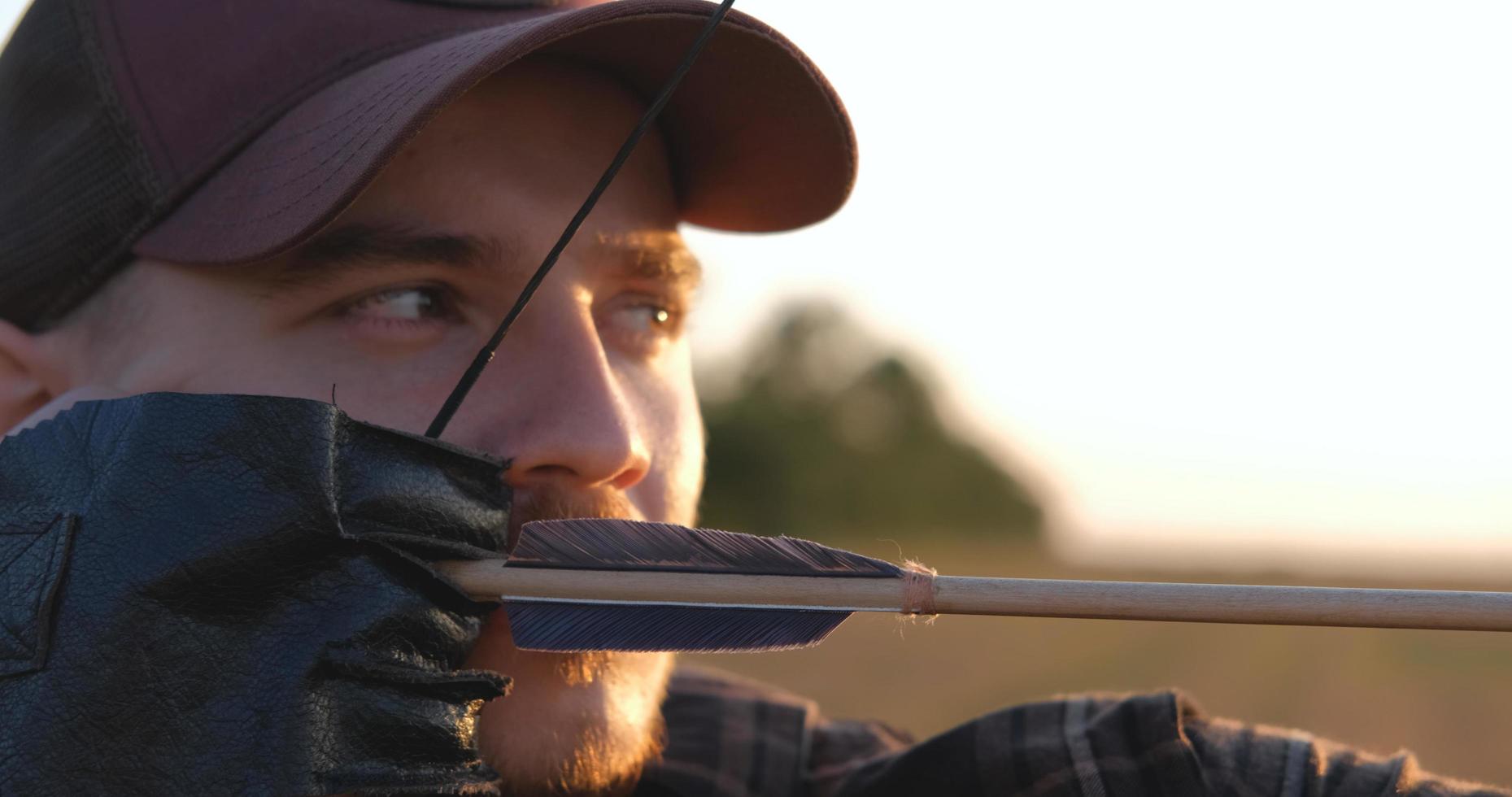 Man with bow outdoors in the field photo