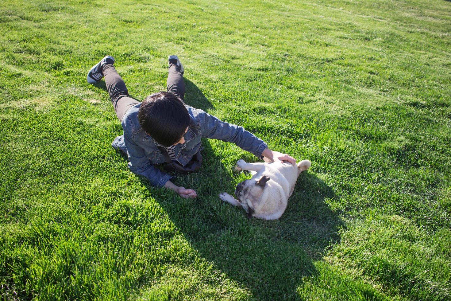 Retrato de mujer joven con perro pug en el parque foto