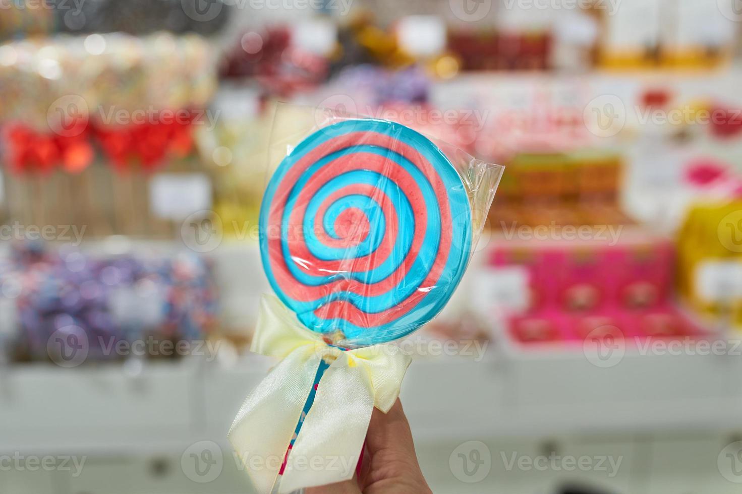 Lollipop with stick on background of shop window. photo