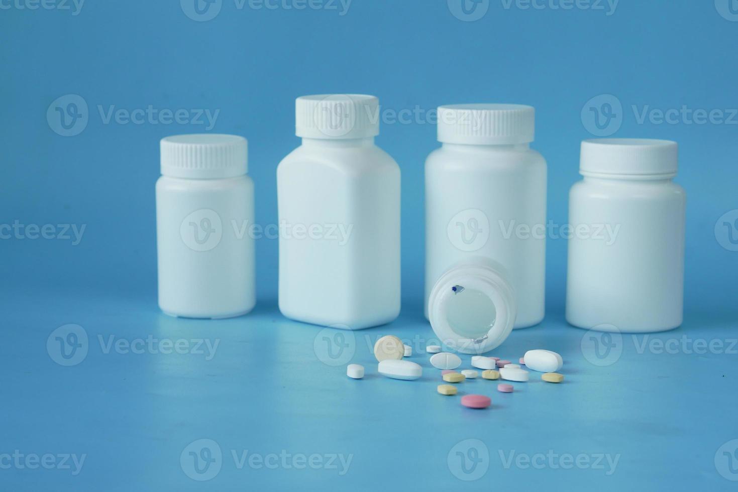 Close up of many colorful pills and capsules on blue background photo