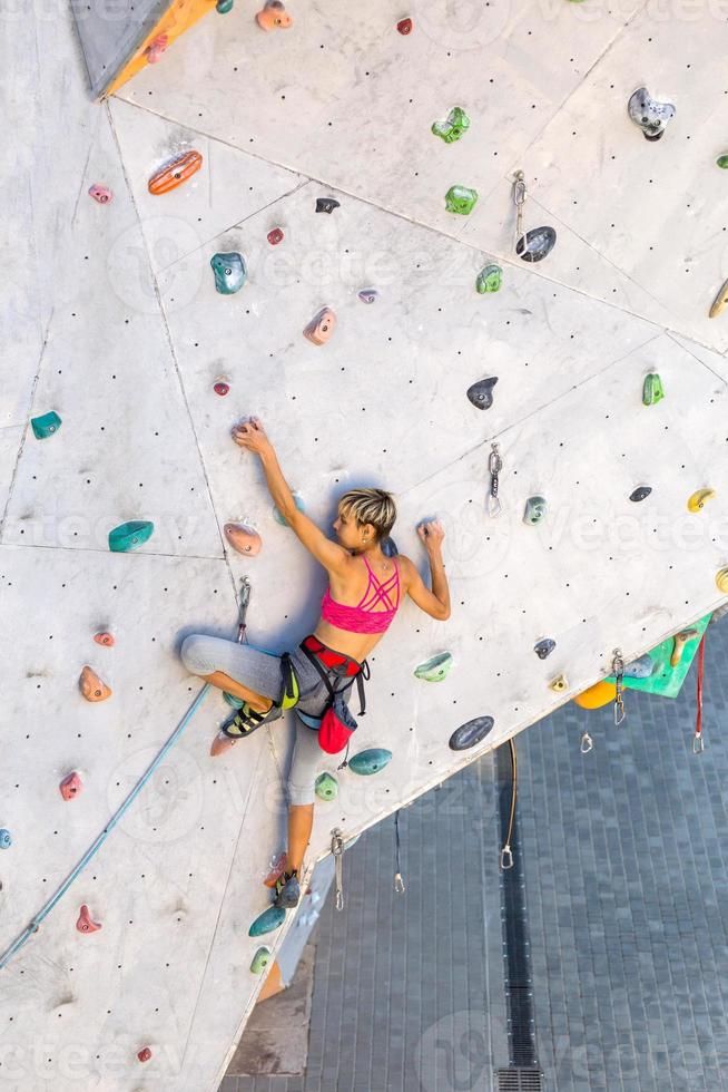 una mujer está escalando un muro de escalada foto