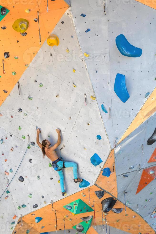 un hombre está escalando un muro de escalada foto