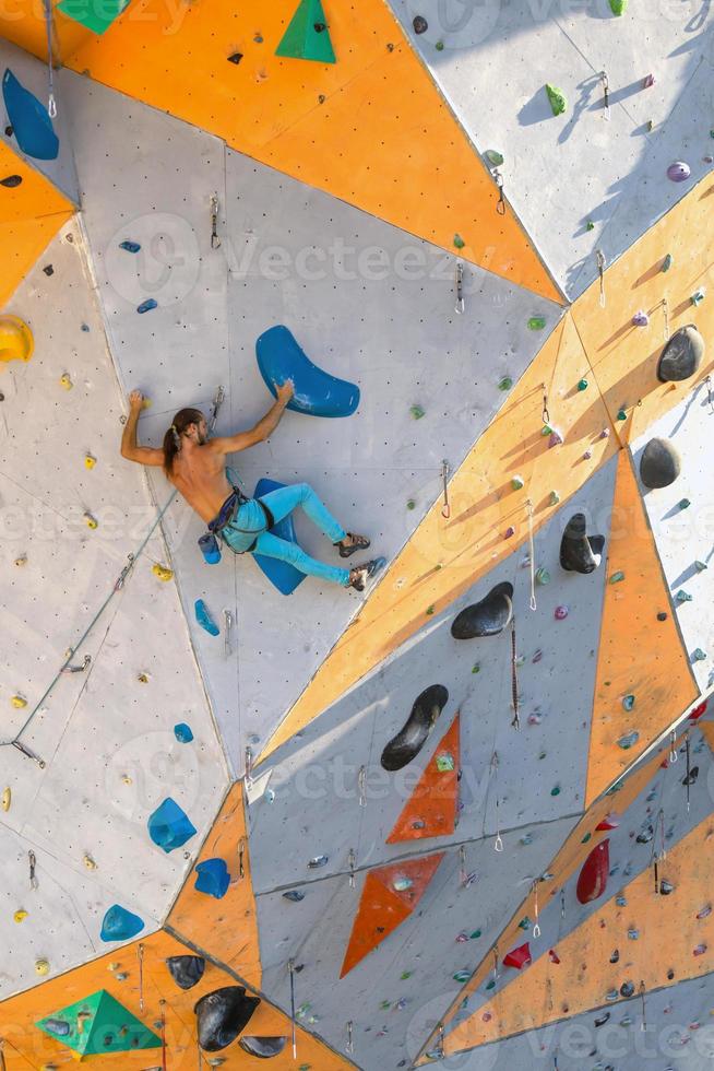 un hombre está escalando un muro de escalada foto