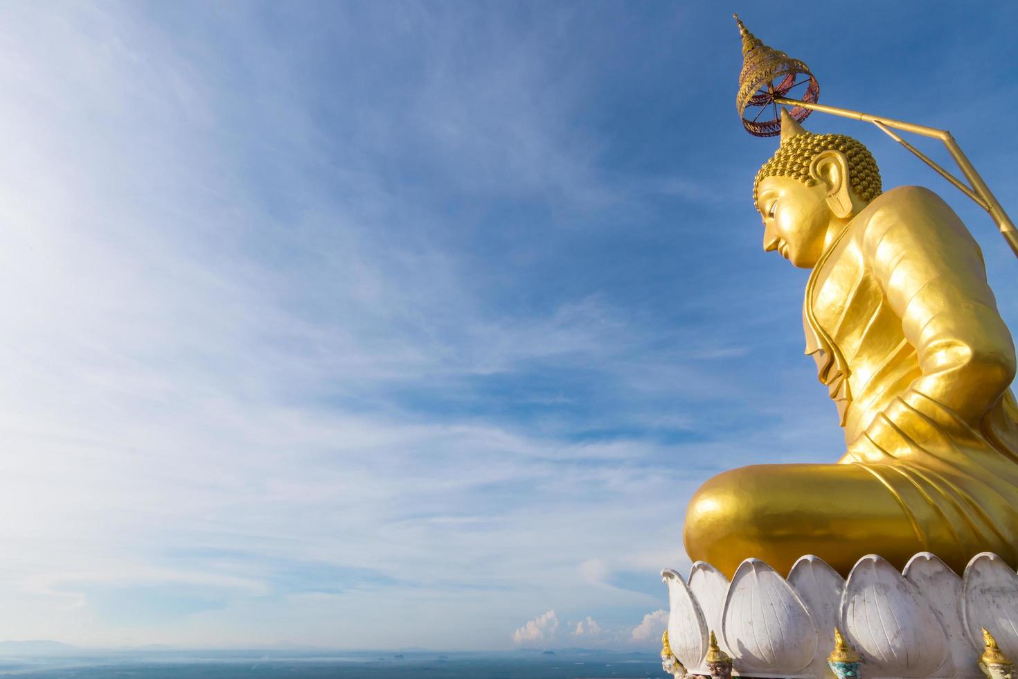 el buda dorado en la cima de la montaña, templo de la cueva del tigre, krabi tailandia foto