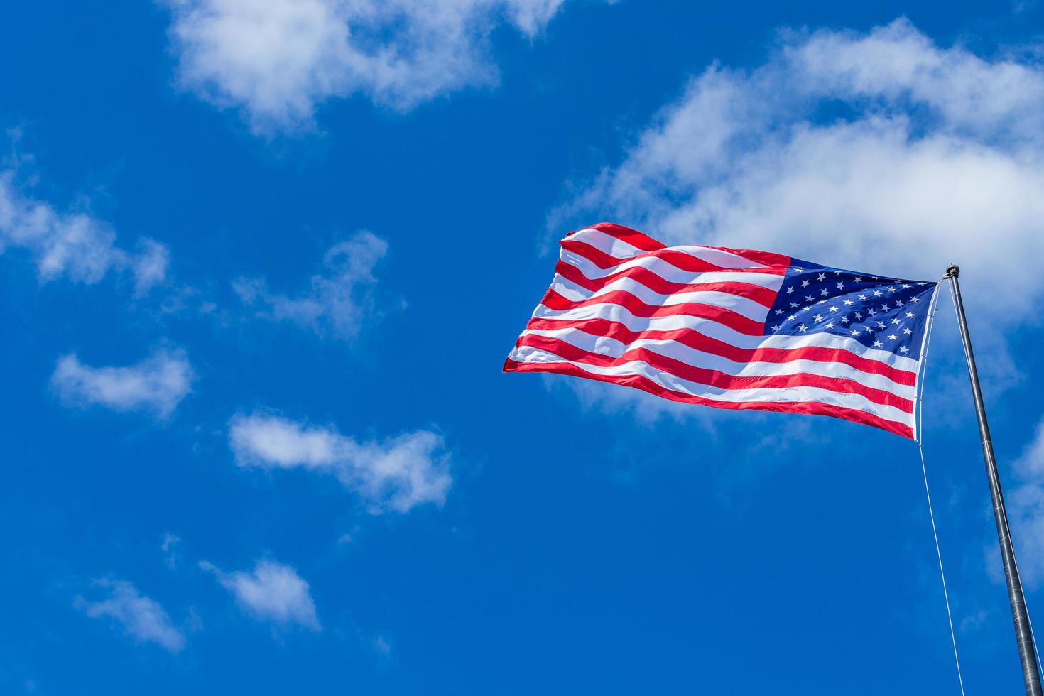 American USA Flag waving with cloudy blue sky on a sunny day photo