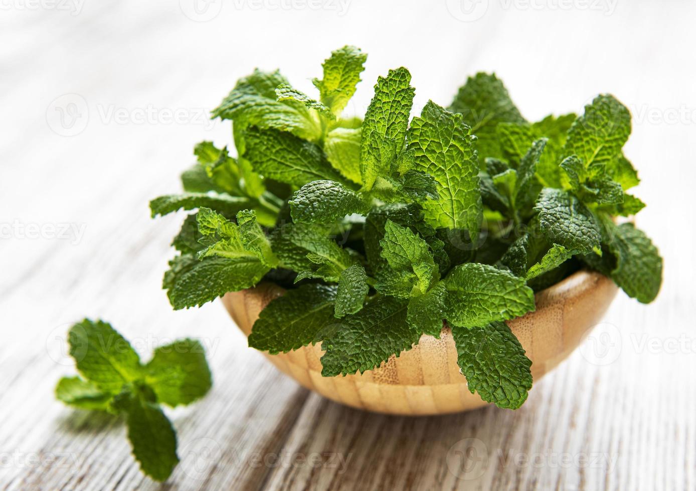 cuenco con un manojo de menta fresca sobre la mesa de madera vieja. el concepto de alimentación saludable. foto