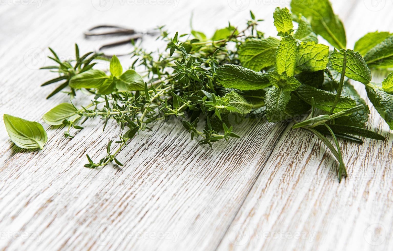 Fresh herbs cut in home garden, on wooden rustic table photo