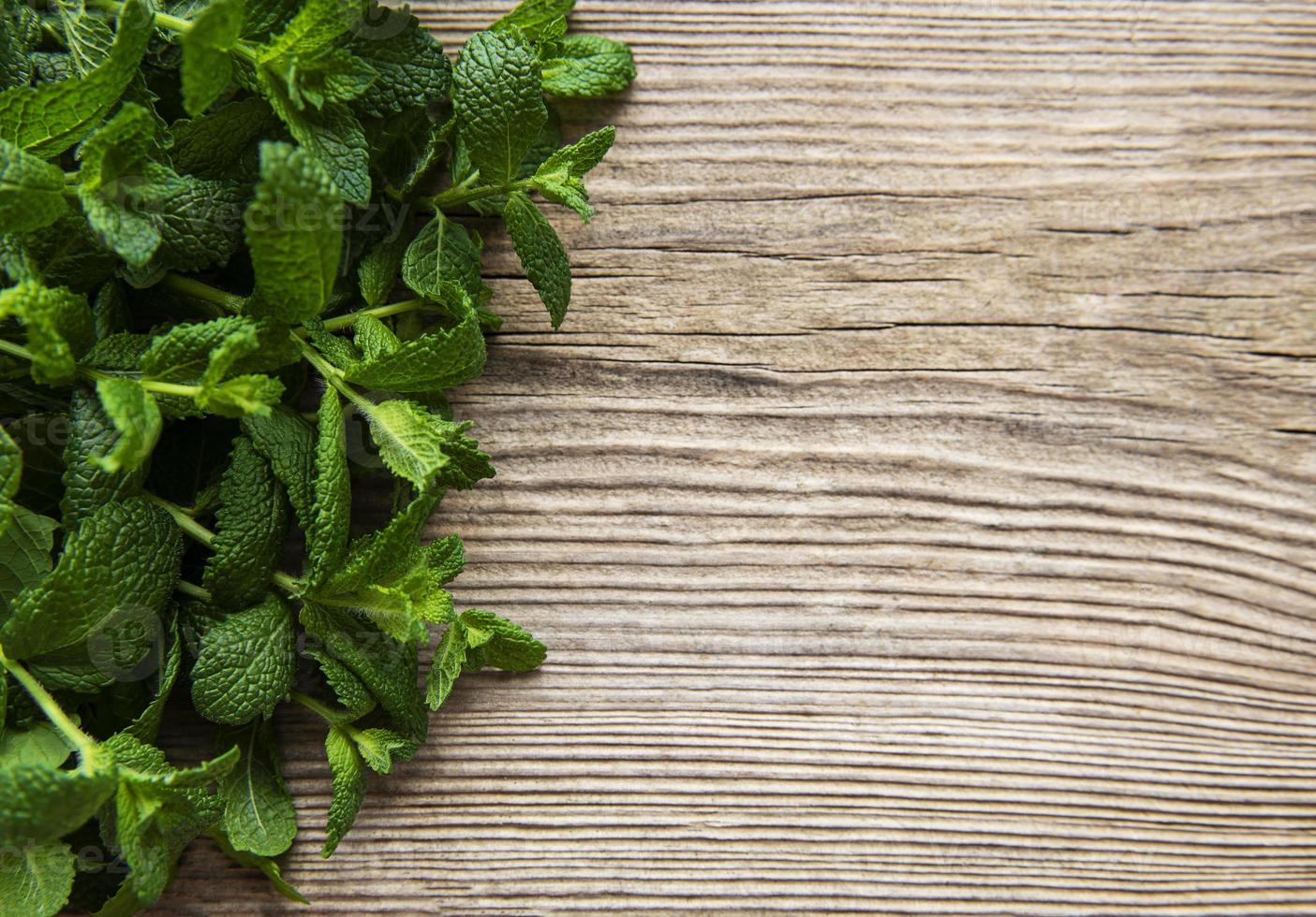 Fresh mint leaves on  old wooden background photo