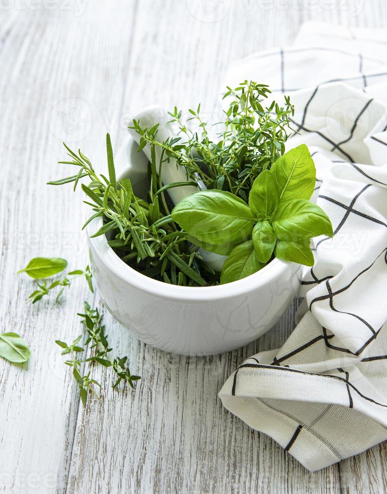Bunch of aromatic herbs in mortar photo