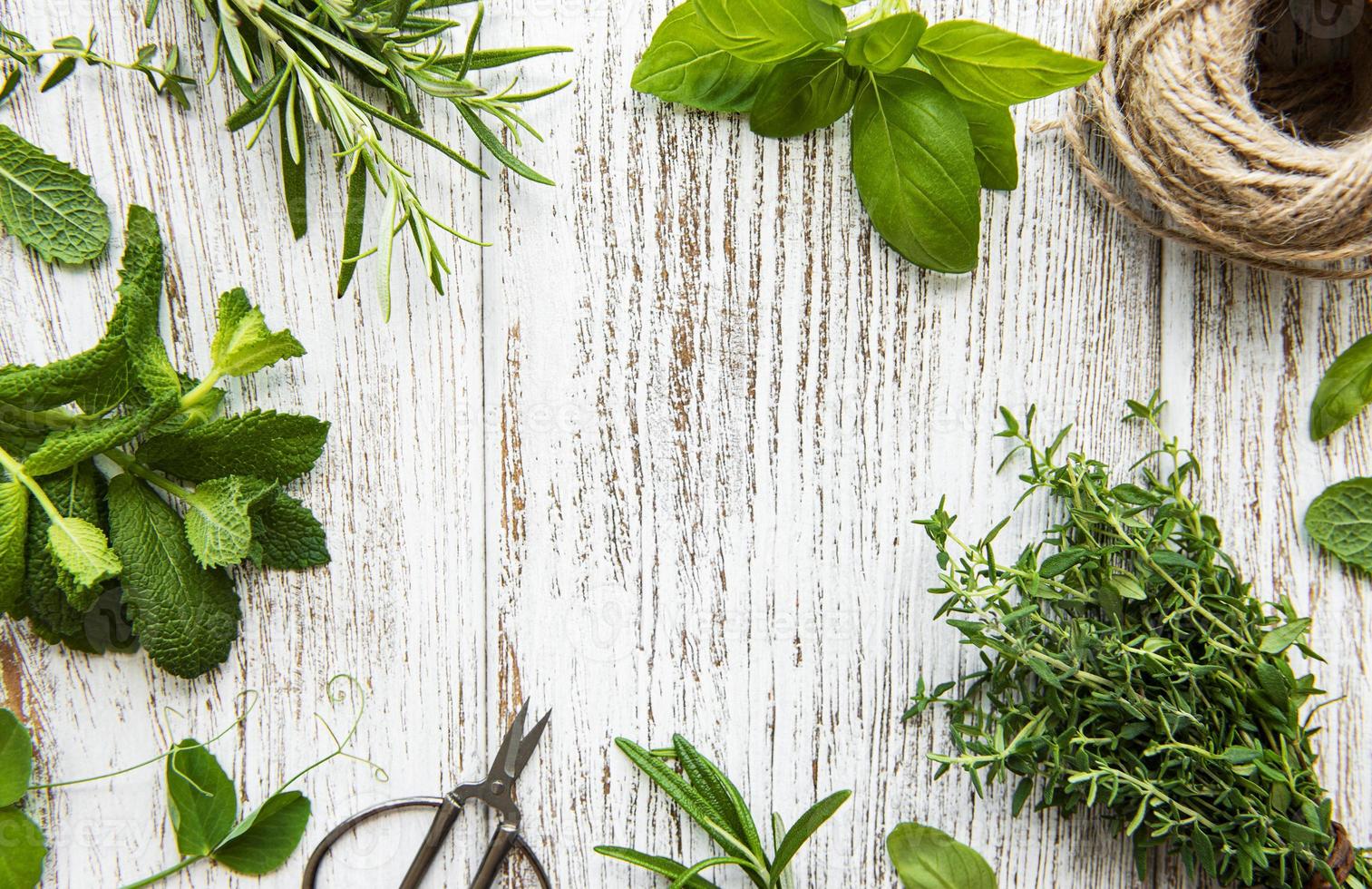 Fresh herbs and twine on wooden background top view photo